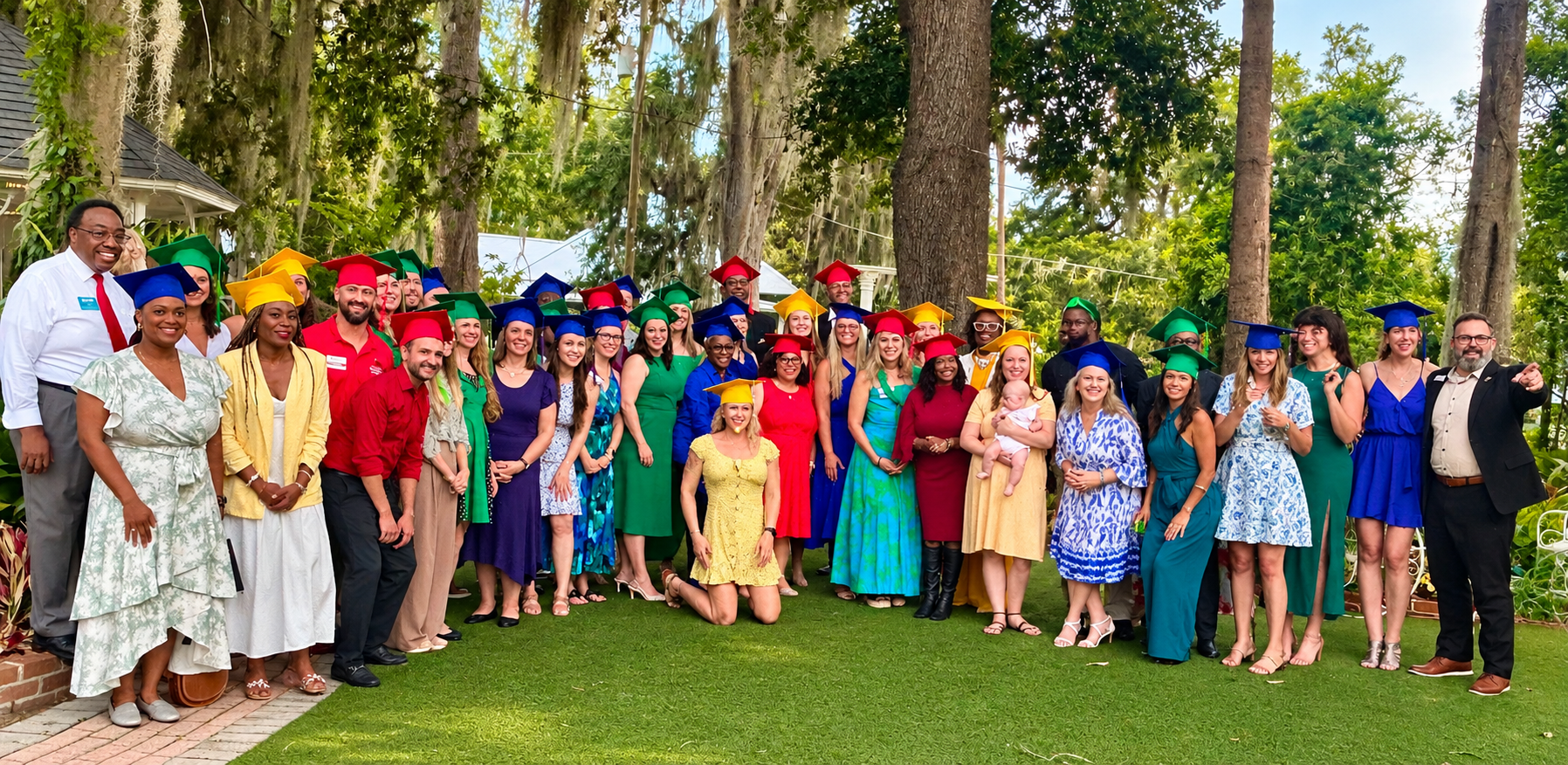 Leadership Gainesville Class 52 graduates celebrating together outdoors in colorful graduation caps.
